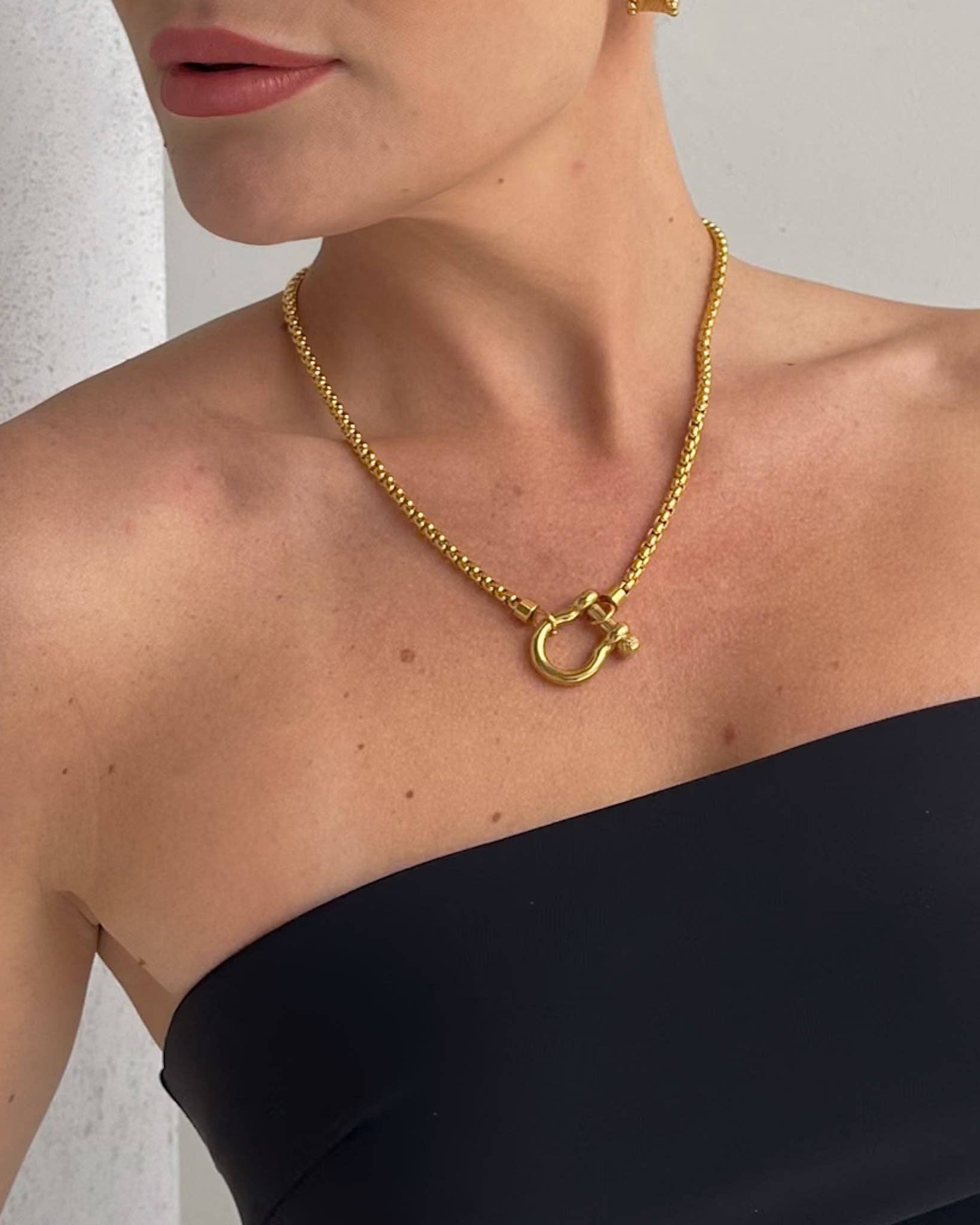 Gold Shackle Chain Necklace features a sleek box chain & bold clasp. 18K gold-plated, waterproof & hypoallergenic.