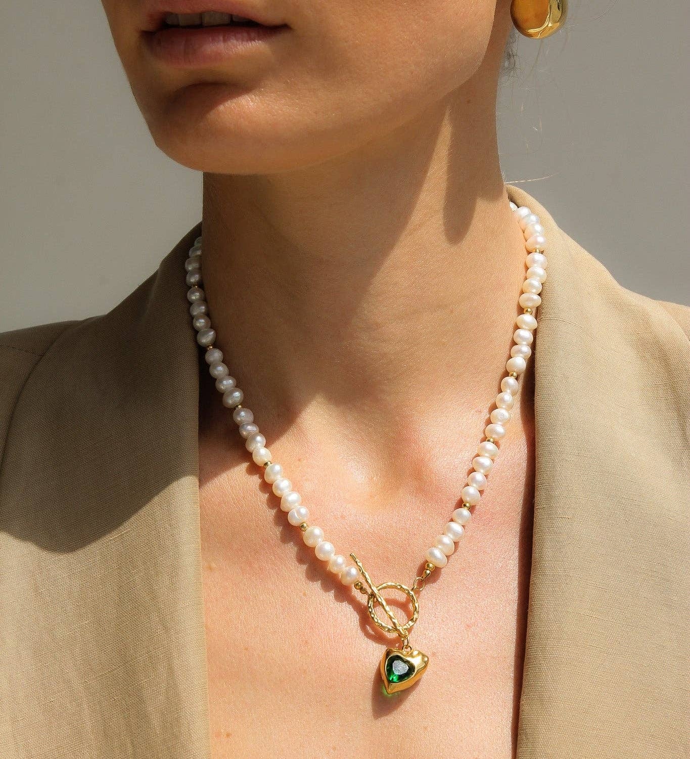 Golden Heart Necklace features a vibrant green heart pendant. 18K gold-plated, waterproof, and hypoallergenic
