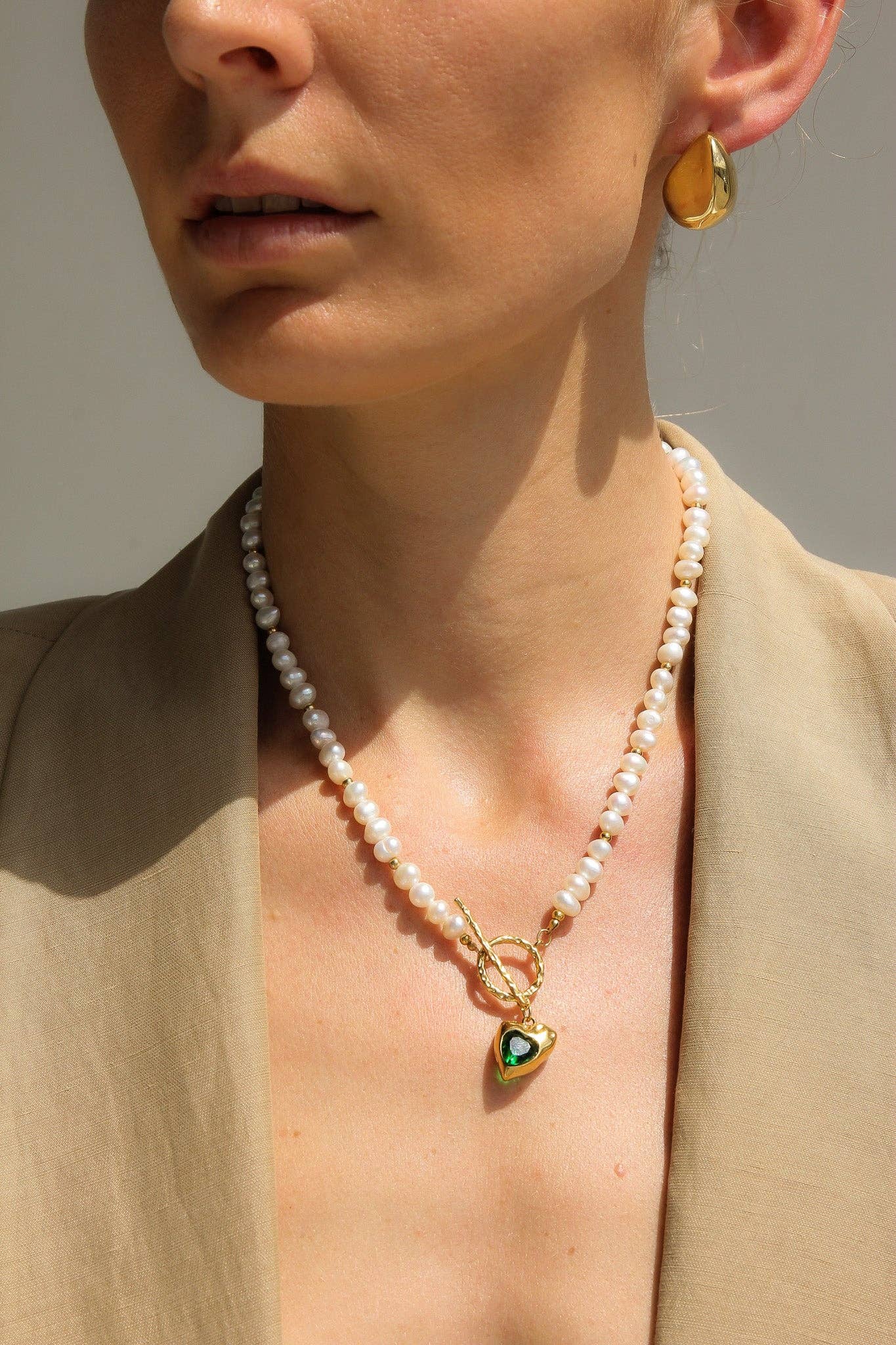 Golden Heart Necklace features a vibrant green heart pendant. 18K gold-plated, waterproof, and hypoallergenic