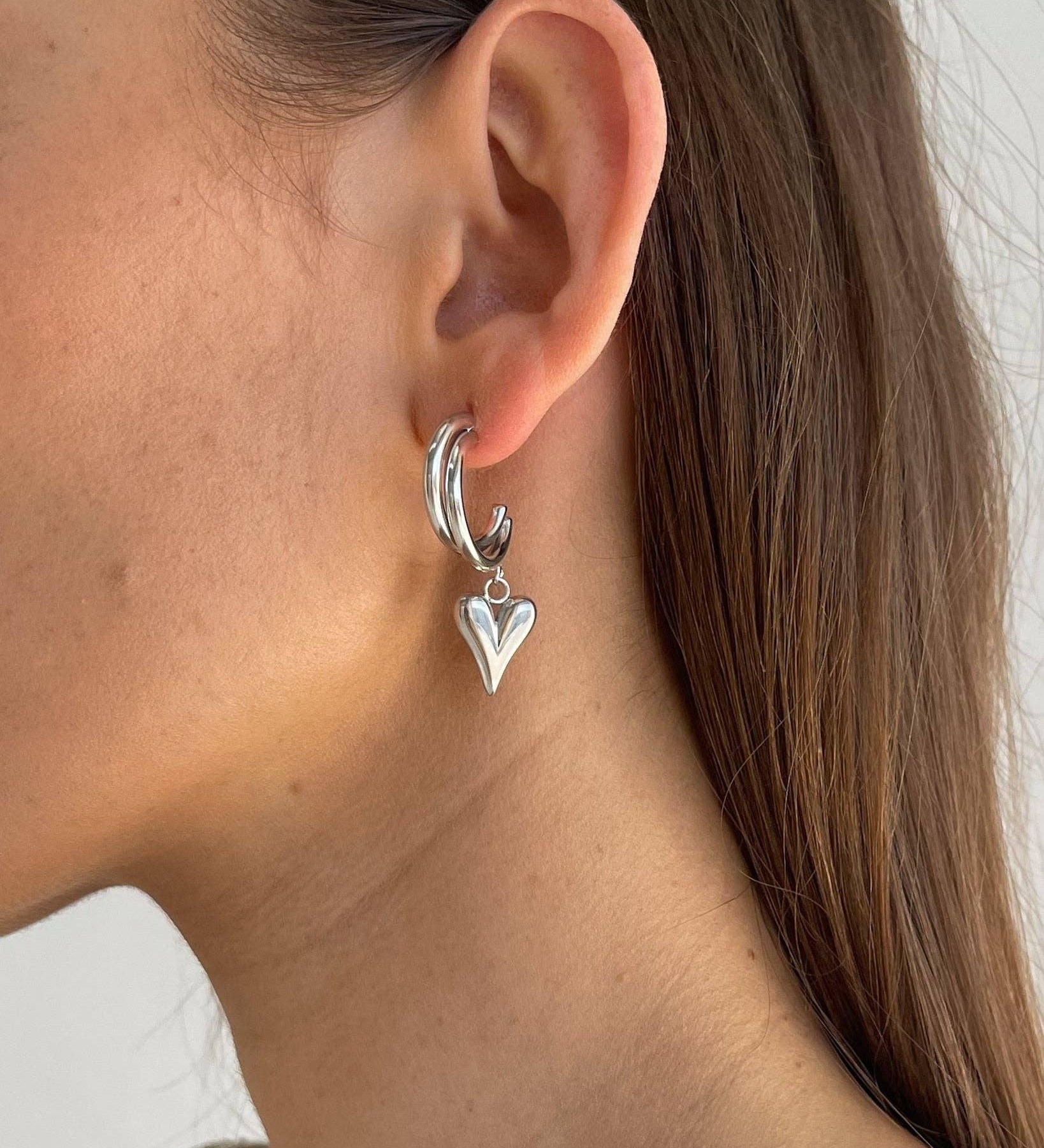 Heart Silver Earrings. Hypoallergenic, tarnish-resistant & waterproof, featuring a delicate heart charm on model