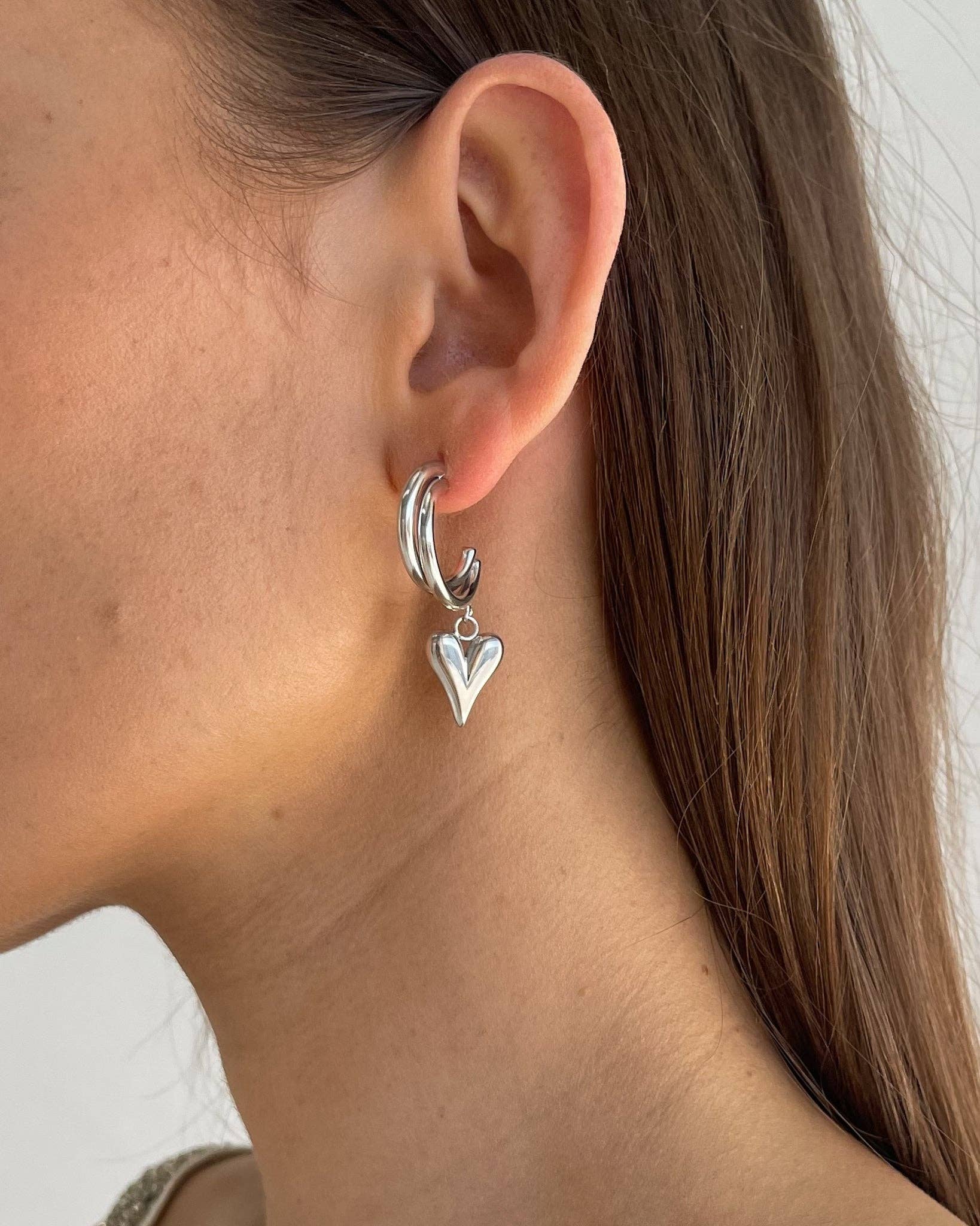 Heart Silver Earrings. Hypoallergenic, tarnish-resistant & waterproof, featuring a delicate heart charm on model
