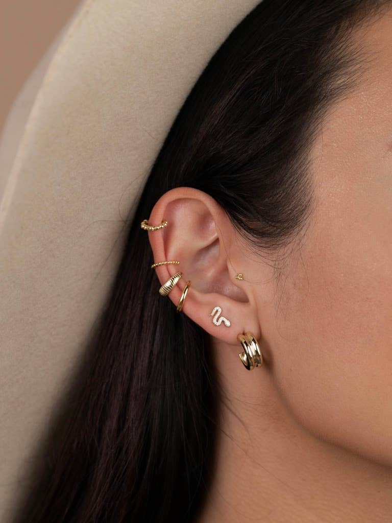 Year of the Snake, these gold-plated stud earrings feature CZ stones on model