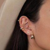 Year of the Snake, these gold-plated stud earrings feature CZ stones on model