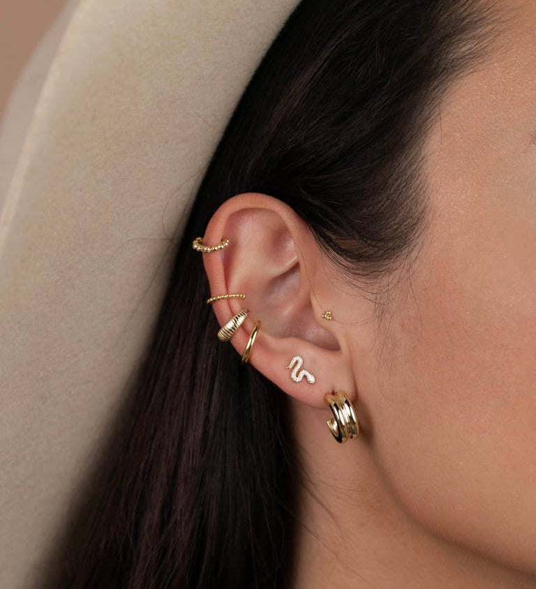 Year of the Snake, these gold-plated stud earrings feature CZ stones on model